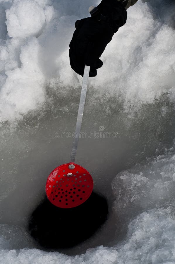 Cleaning out a hole for ice fishing