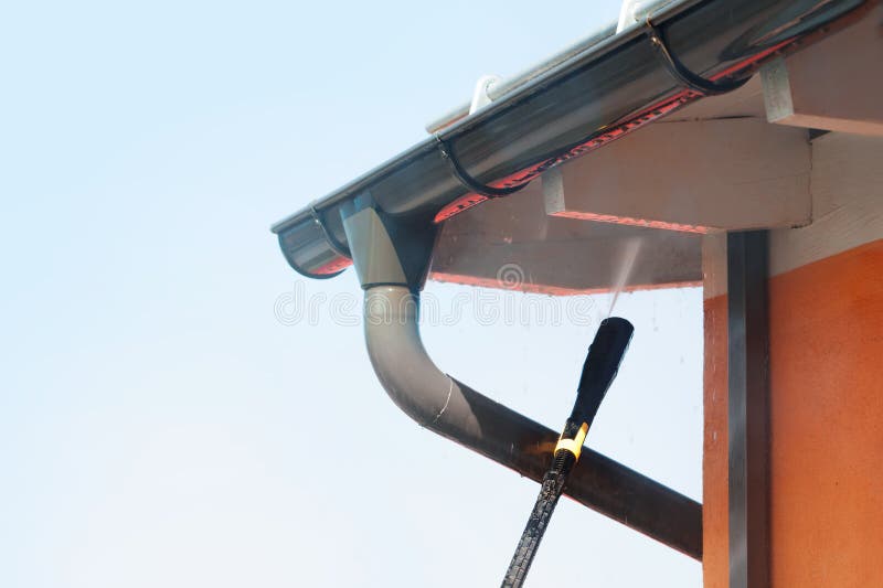 Cleaning the roof, eaves, drainpipe and wall of the house against the sky