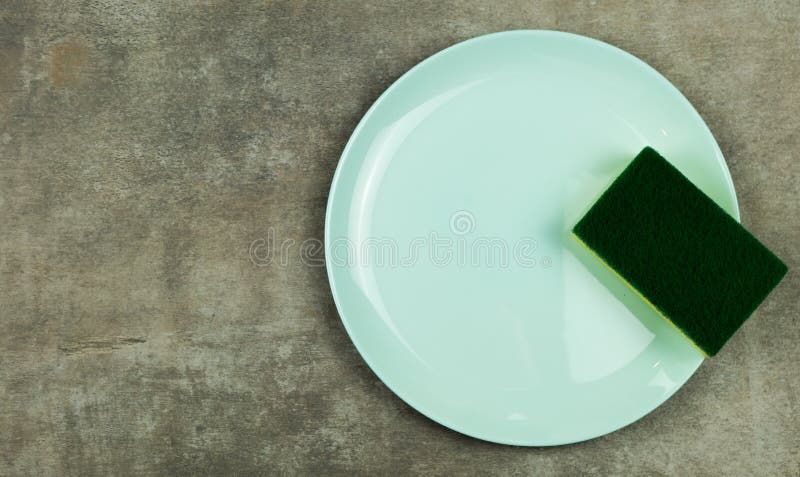 Cleaning Sponge On A Green Plate On A Gray Background