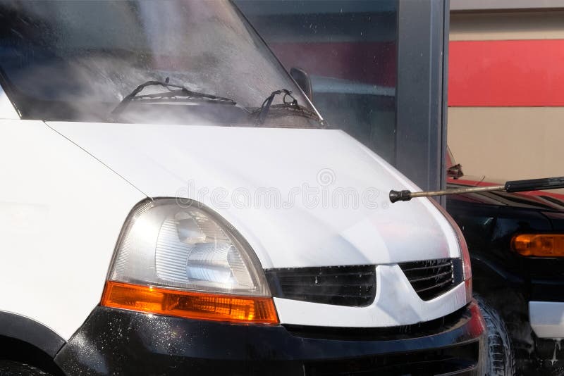Cleaning with Water at Selfservice Car Wash. Wash Windshield in White