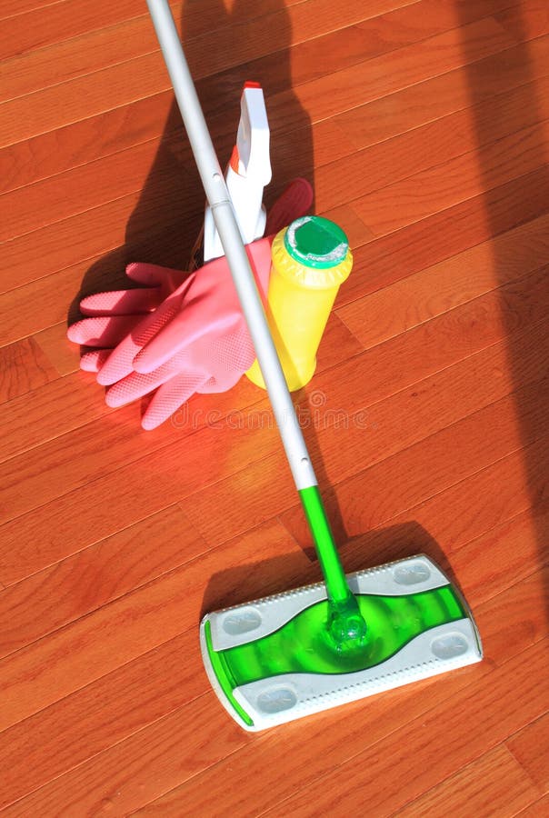 House cleaning tools with mop, glove, and cleaning products on hardwood floor at home. House cleaning tools with mop, glove, and cleaning products on hardwood floor at home