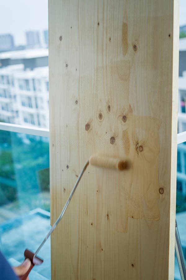 Clear Coat Paint on a Wooden Board. Motion Roller Brush Painting Stock