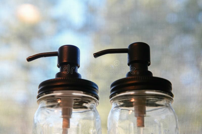 Clear Jars with Pump Tops on Window Sill royalty free stock image