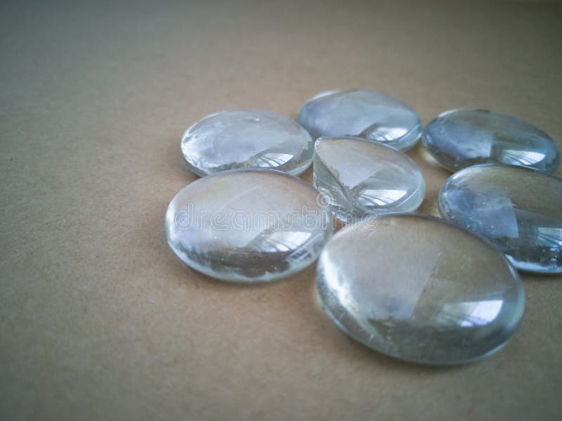 Clear Marbles with Light Reflections on a Brown Background. Stock Image