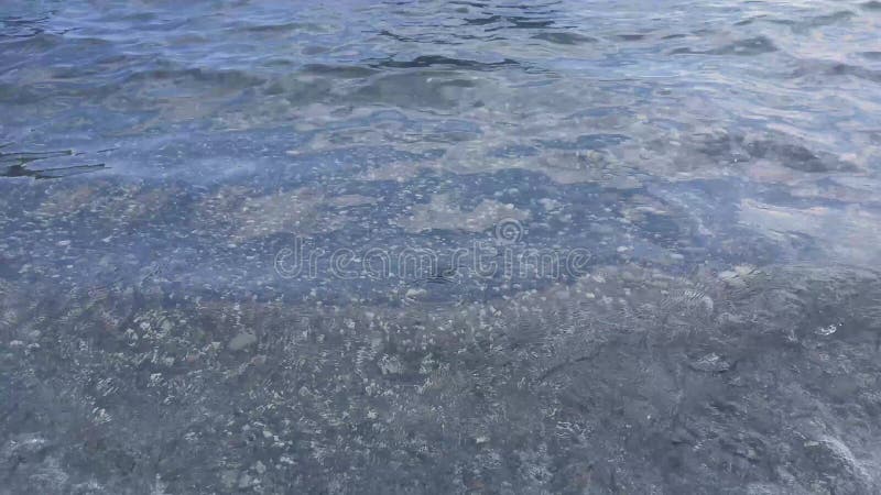 Clear sea water. waves on pebble beach