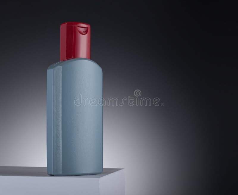 Clear Shampoo Bottle with a Red Lid Sits on a Crisp White Surface
