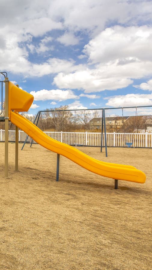 Clear Vertical Playground With Slides And Swings Under The Blue Sky