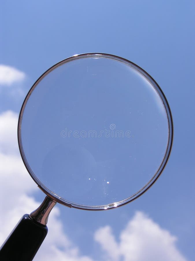 Clear vision. Magnifying glass pointed at clear blue sky Clear vision. Magnifying glass pointed at clear blue sky