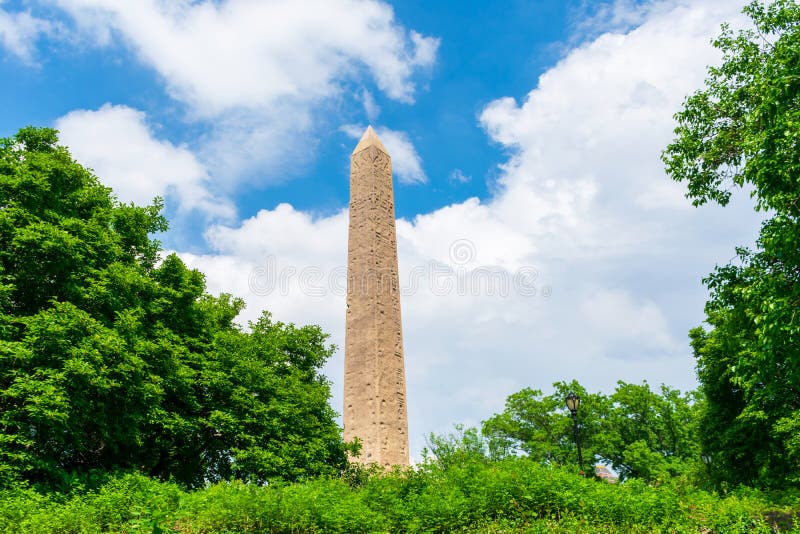 Cleopatra`s Needle Egyptian obelisk in Central Park. Green trees. Blue sky. - New York, USA - 2021