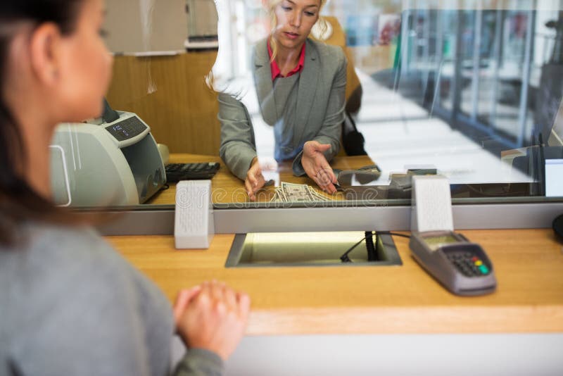 Clerk with cash money and customer at bank office. People, withdrawal, saving and finance concept - clerk with cash money and customer at bank office or currency royalty free stock photos Clerk with cash money and customer at bank office. People, withdrawal, saving and finance concept - clerk with cash money and customer at bank office or currency royalty free stock photos