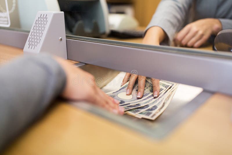 Clerk giving cash money to customer at bank office