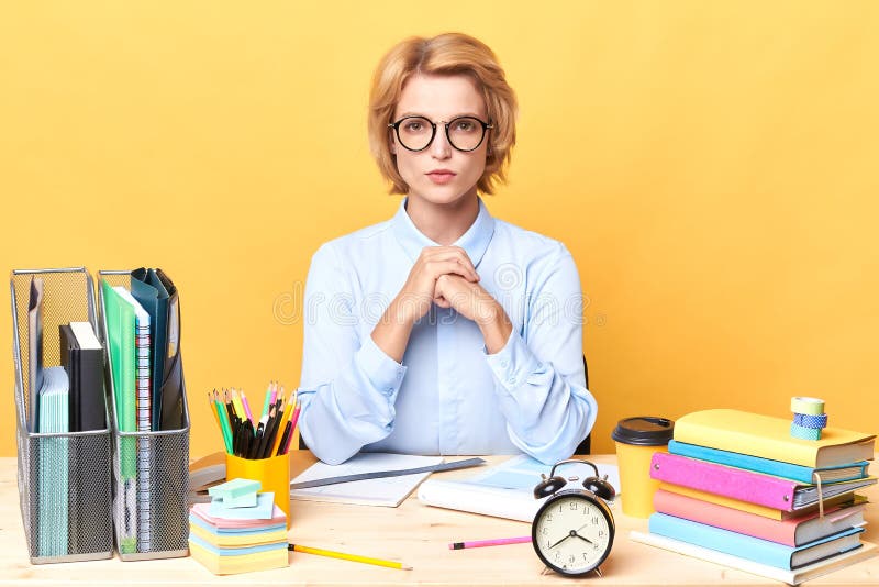 Clever pleasant woman in light blue shirt spending time in the office stock images Clever pleasant woman in light blue shirt spending time in the office stock images