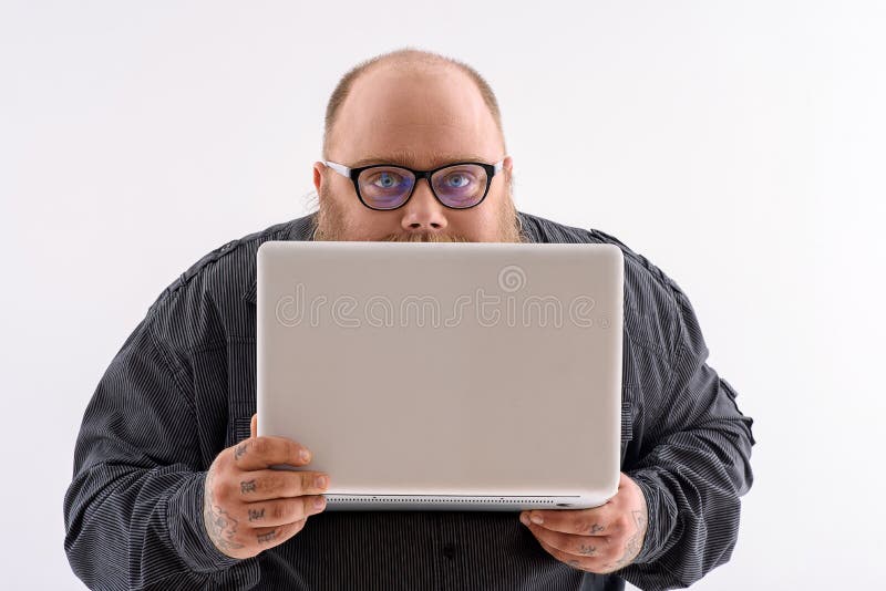 Fat smart man is working on laptop. 