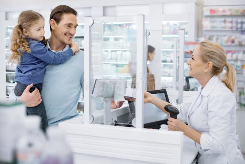 Client de aide de pharmacien féminin expérimenté photographie stock Client de aide de pharmacien féminin expérimenté photographie stock