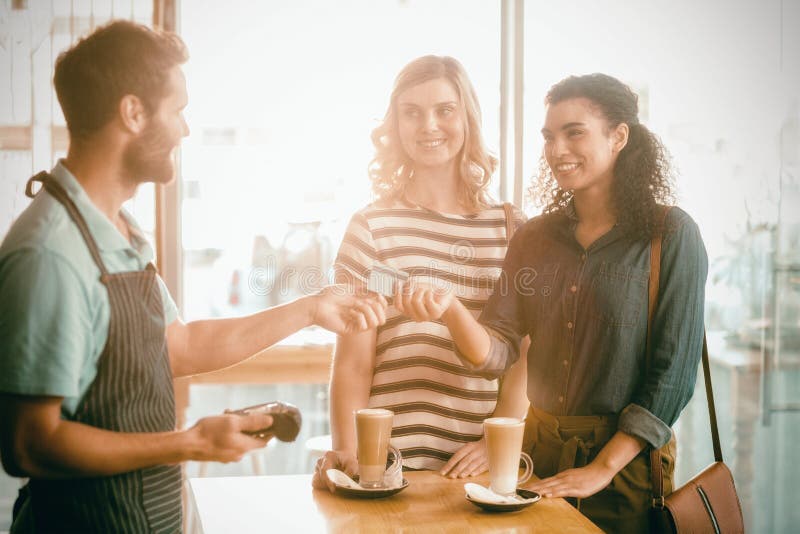 Client effectuant le paiement par le terminal de paiement photographie stock Client effectuant le paiement par le terminal de paiement photographie stock
