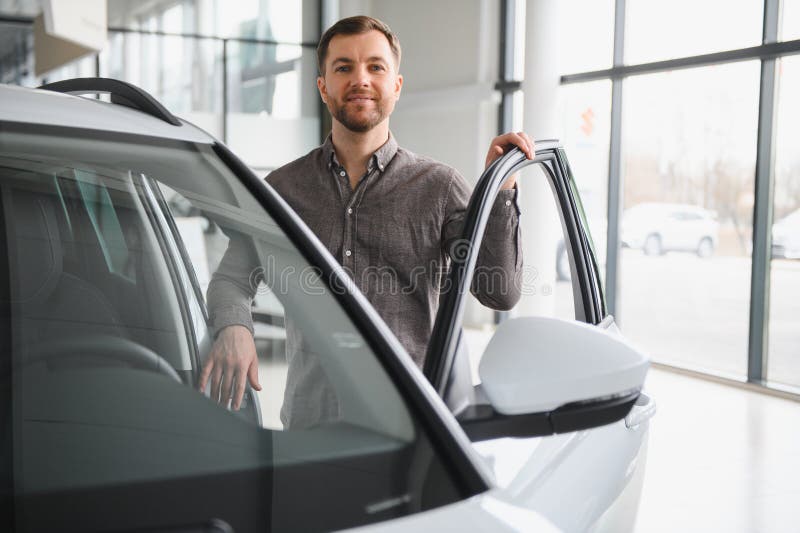 Cliente che sceglie una nuova auto in una vetrina dei dealer fotografia stock