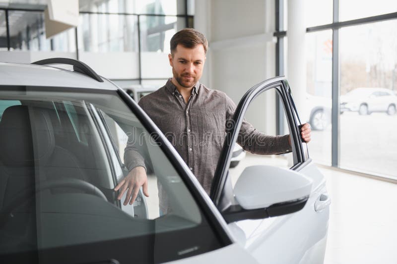 Cliente che sceglie una nuova auto in una vetrina dei dealer fotografie stock libere da diritti