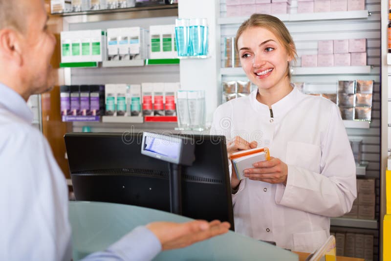 Cliente do serviço do farmacêutico na farmácia imagem de stock Cliente do serviço do farmacêutico na farmácia imagem de stock