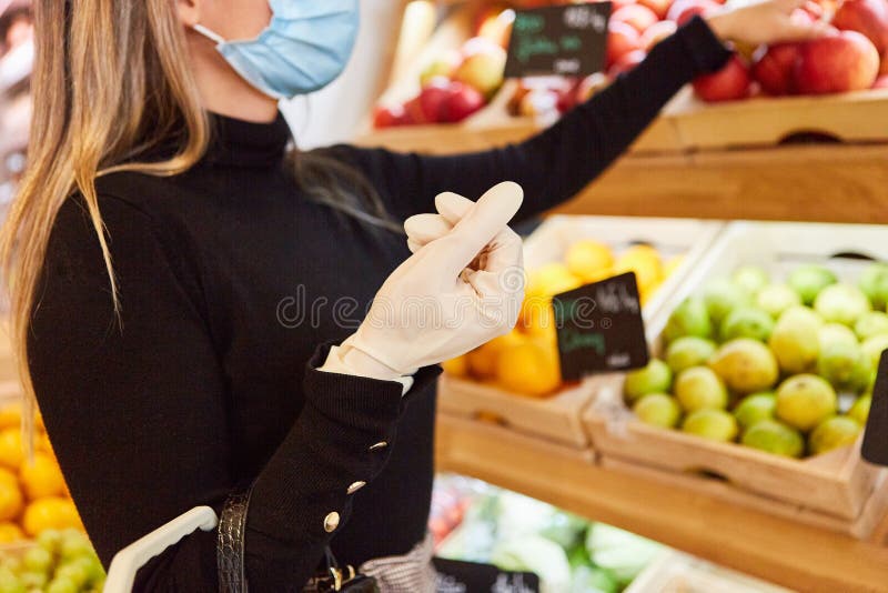 Customer with disposable gloves shopping for fruit in the supermarket because of Covid-19. Customer with disposable gloves shopping for fruit in the supermarket because of Covid-19