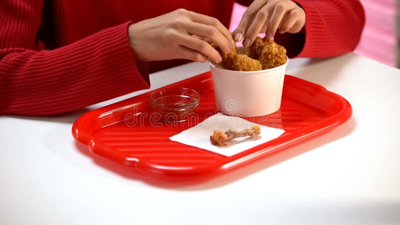 Cliente dos restaurantes que come as asas de galinha crocantes, ossos que encontram-se na tabela, alimento fotos de stock royalty free Cliente dos restaurantes que come as asas de galinha crocantes, ossos que encontram-se na tabela, alimento fotos de stock royalty free