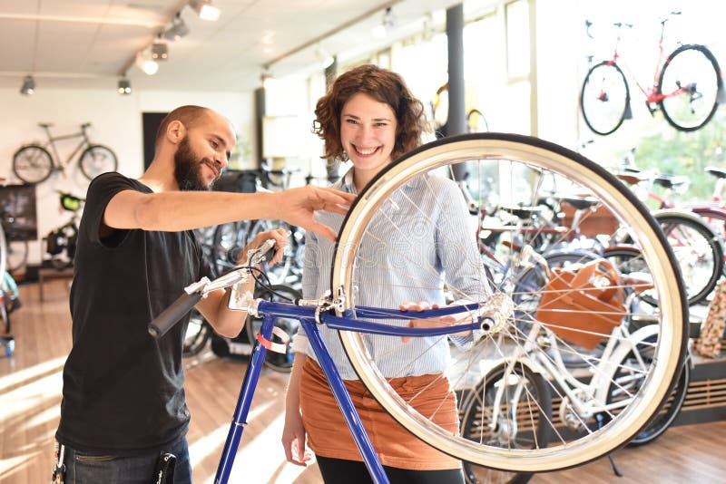 Cliente e commerciante nel negozio della bicicletta - acquisti e la riparazione delle biciclette - servizio di assistenza al clie fotografie stock Cliente e commerciante nel negozio della bicicletta - acquisti e la riparazione delle biciclette - servizio di assistenza al clie fotografie stock