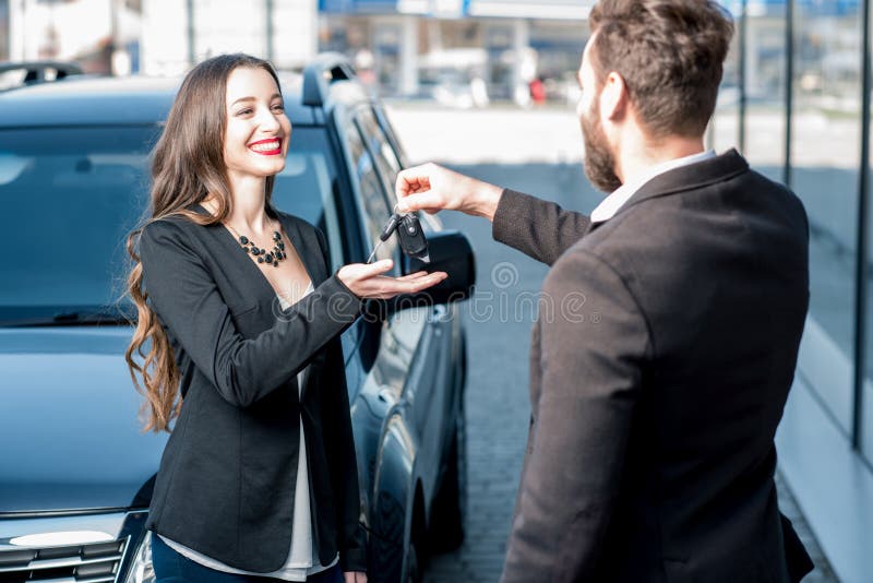 Cliente e venditore felici vicino all'automobile fotografia stock Cliente e venditore felici vicino all'automobile fotografia stock