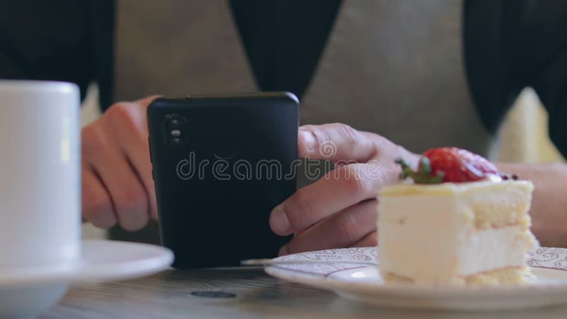 Cliente en cafe usando smartphone durante la pausa del café almacen de video
