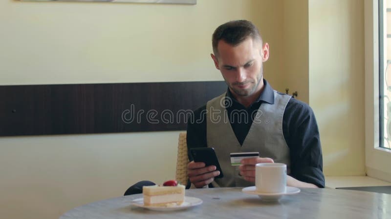 Cliente en una cafetería realiza pagos en línea almacen de video