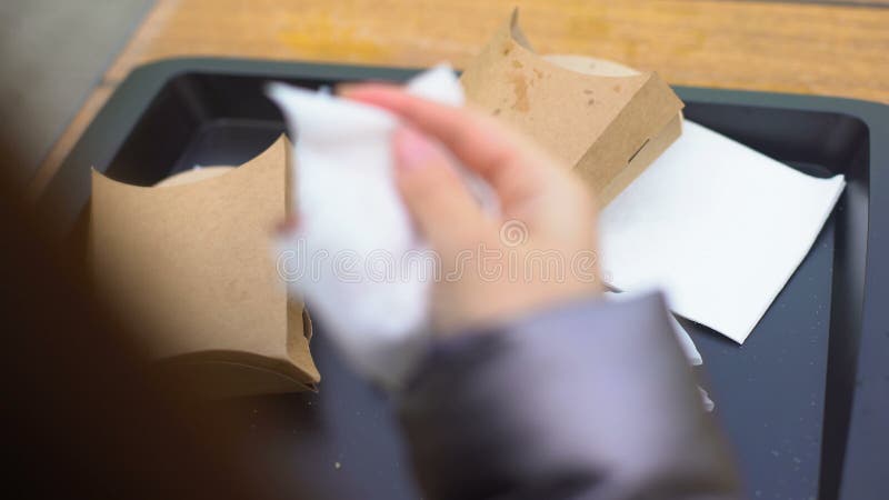 Cliente femminile che getta tessuto usato sul vassoio di plastica e che va, disattenzione