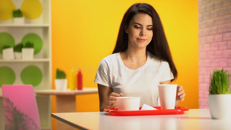 Cliente femminile che mette vassoio di plastica sulla tavola, cena in fast food