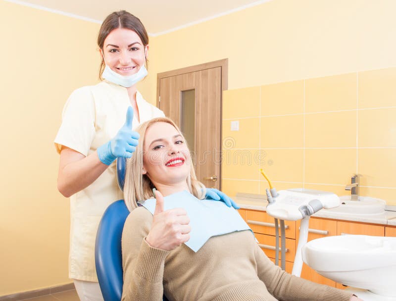 Cliente femminile soddisfatto in ufficio dentario immagini stock Cliente femminile soddisfatto in ufficio dentario immagini stock