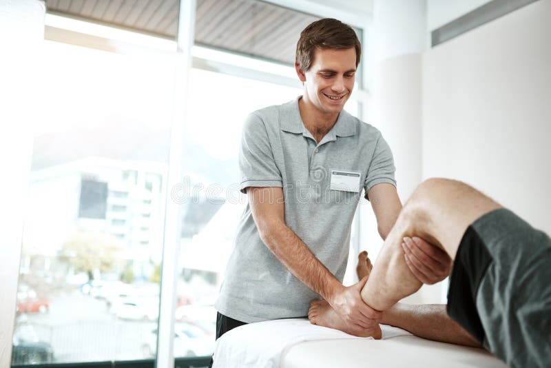Cliente o fisioterapista con riabilitazione della gamba in ufficio per lesioni al ginocchio per supporto ortopedico. Trattamento d fotografia stock