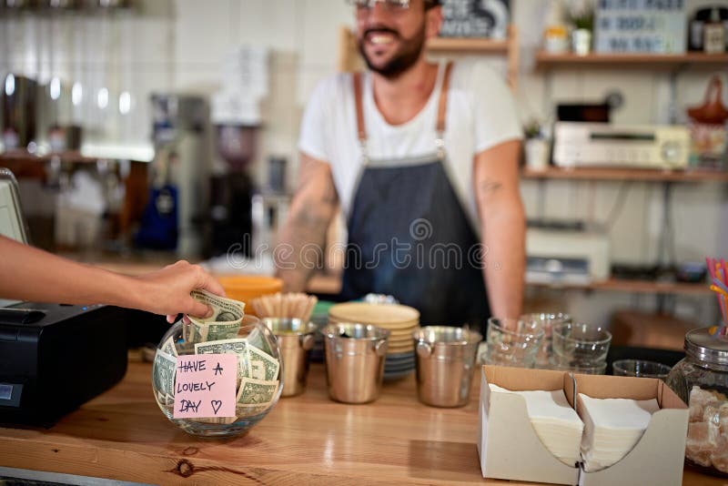 Cliente satisfecho dejando la punta en un bol con un mensaje positivo en una pegatina. mensaje positivo satisfecho fotografía de archivo libre de regalías Cliente satisfecho dejando la punta en un bol con un mensaje positivo en una pegatina. mensaje positivo satisfecho fotografía de archivo libre de regalías