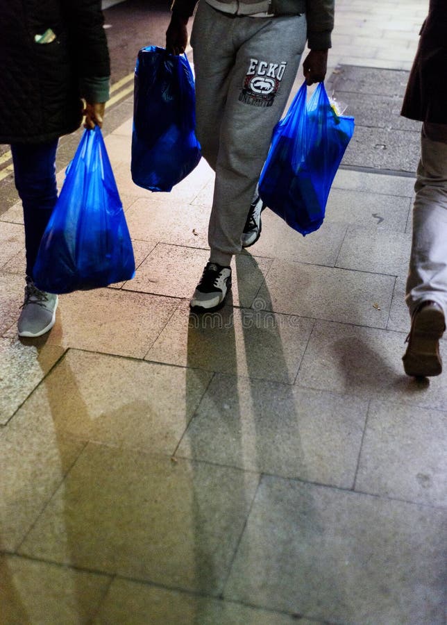 Clientes em sacos de plástico levando da noite fotografia de stock Clientes em sacos de plástico levando da noite fotografia de stock