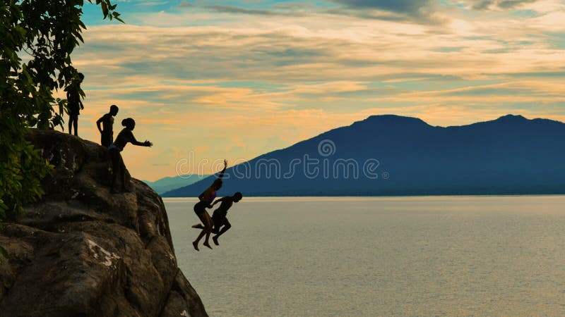 Cliff diving against a golden sunset at Kande Beach, Nkhata Bay, Lake Malawi, Malawi. Cliff diving against a golden sunset at Kande Beach, Nkhata Bay, Lake Malawi, Malawi