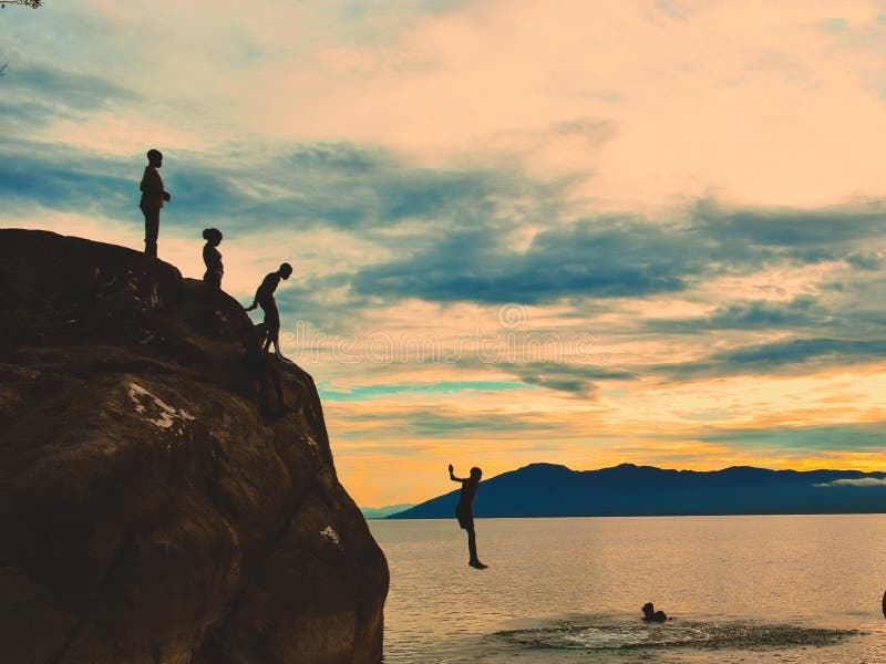 Cliff diving against a golden sunset at Kande Beach, Nkhata Bay, Lake Malawi, Malawi. Cliff diving against a golden sunset at Kande Beach, Nkhata Bay, Lake Malawi, Malawi