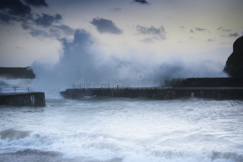 Vlny zřítilo nad přístavní zdi ve Sloupku Cove, Cornwall.