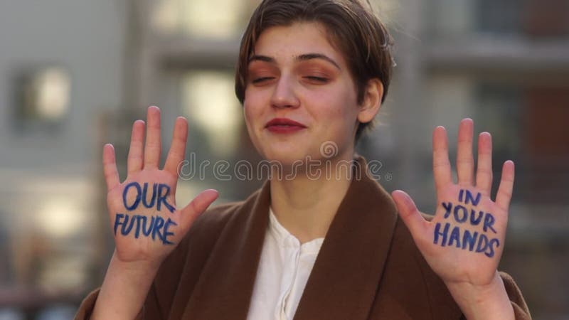 Climatic strike. A young girl with an inscription on her hand - our future is in your hands. Global climate change