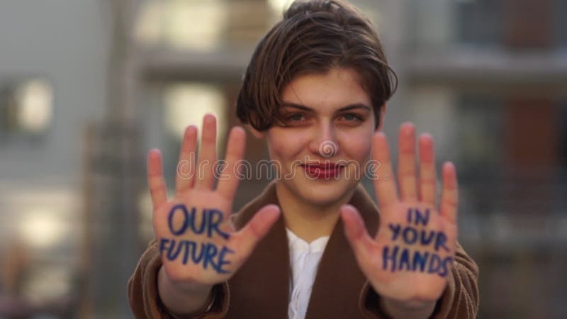 Climatic strike. A young girl with a short haircut with an inscription on her hand - our future is in your hands. Global