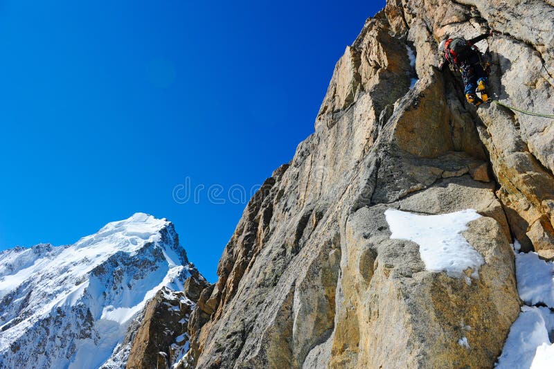 Climber reaching the summit of mountain royalty free stock image