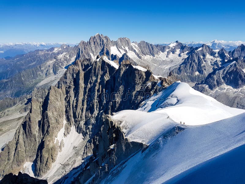 Climbers walk towards the top of the mountain. Climbers walk towards the top of the mountain