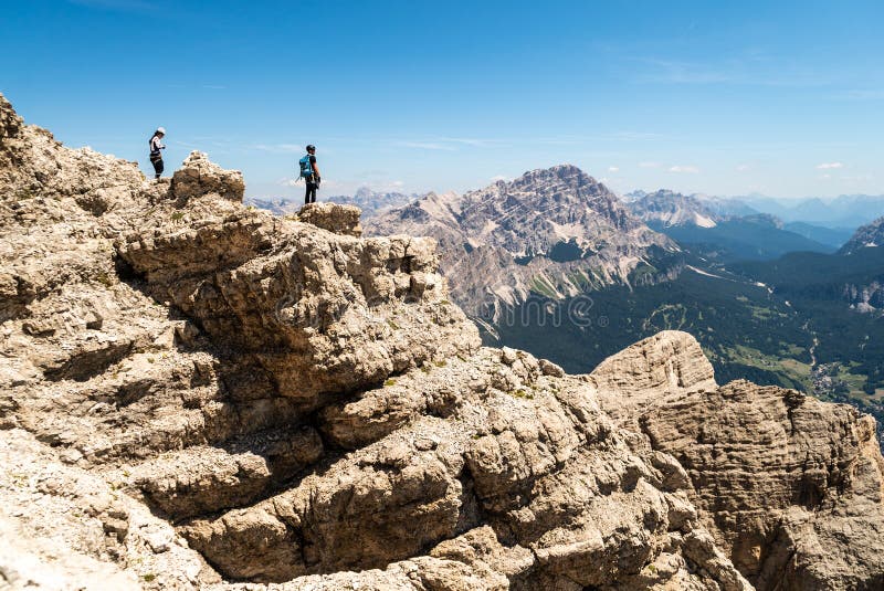 Climbers silhouette standing on a cliff in Dolomites. Tofana di Mezzo, Punta Anna, Italy. Man Celebrate success on top of the moun