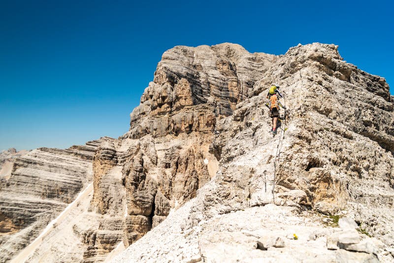 Climbers silhouette standing on a cliff in Dolomites. Tofana di Mezzo, Punta Anna, Italy. Man Celebrate success on top of the moun