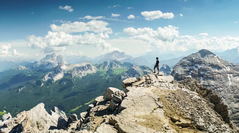 Climbers silhouette standing on a cliff in Dolomites. Tofana di Mezzo, Punta Anna, Italy. Man Celebrate success on top of the moun