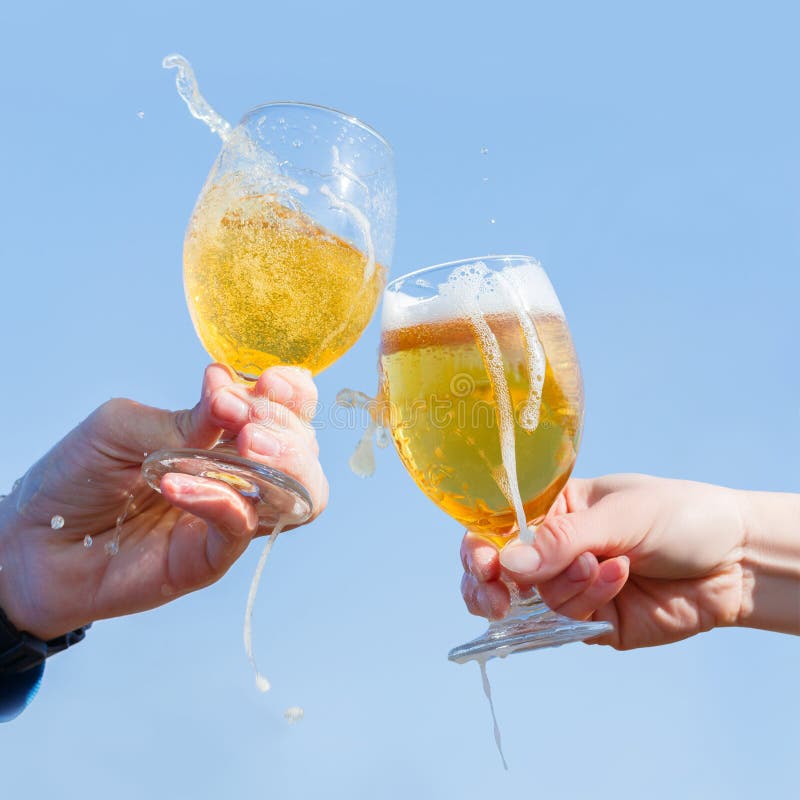 Clinking Beer Glasses on Winter Forest Background. Stock Photo Image