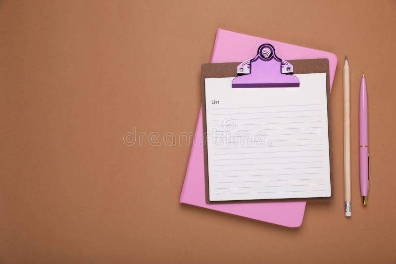 Clipboard with to do notes, planner, pen and pencil on brown background, flat lay. Space for text royalty free stock image