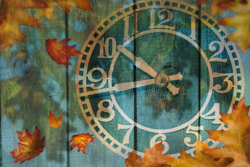 Clock and autumn leaves background - daylight saving time concept