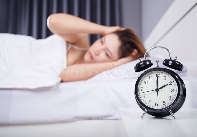Clock with woman sleepless on bed stock image Clock with woman sleepless on bed stock image