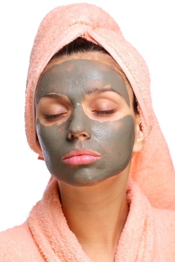 Close face of young woman with a mud mask on it.