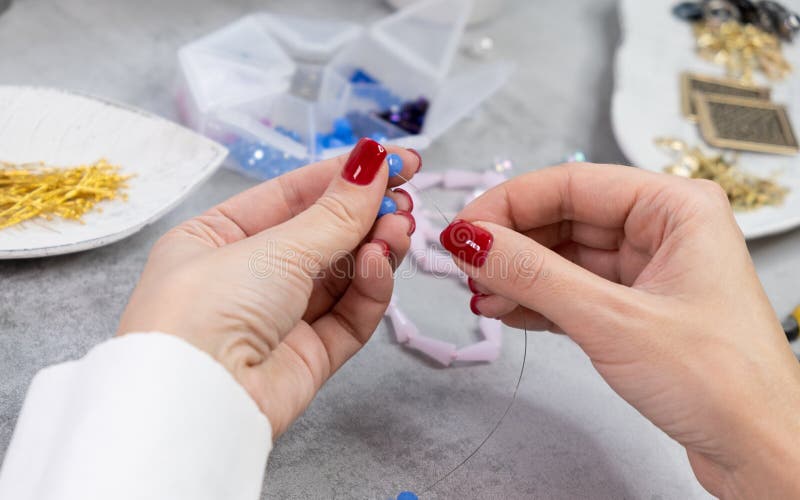 Close hand jeweler stringing pearls on a necklace. royalty free stock photos